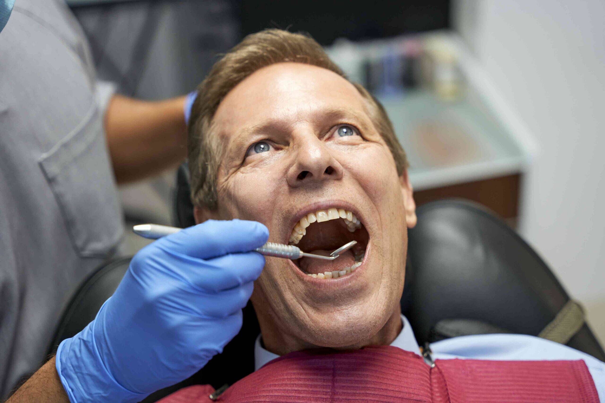 Patient receiving a dental exam in a dental chair.
