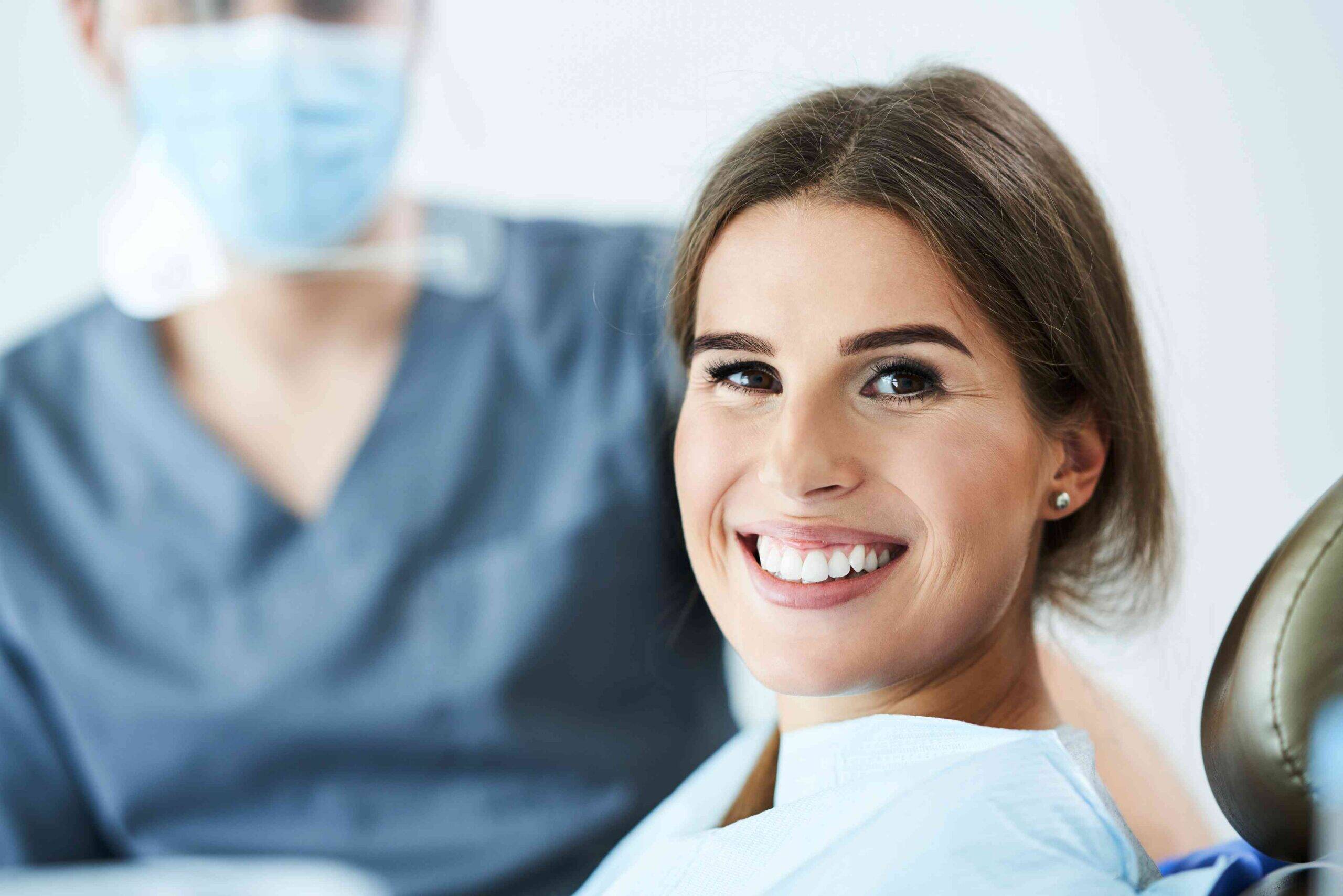 Smiling patient in a dental chair after treatment.